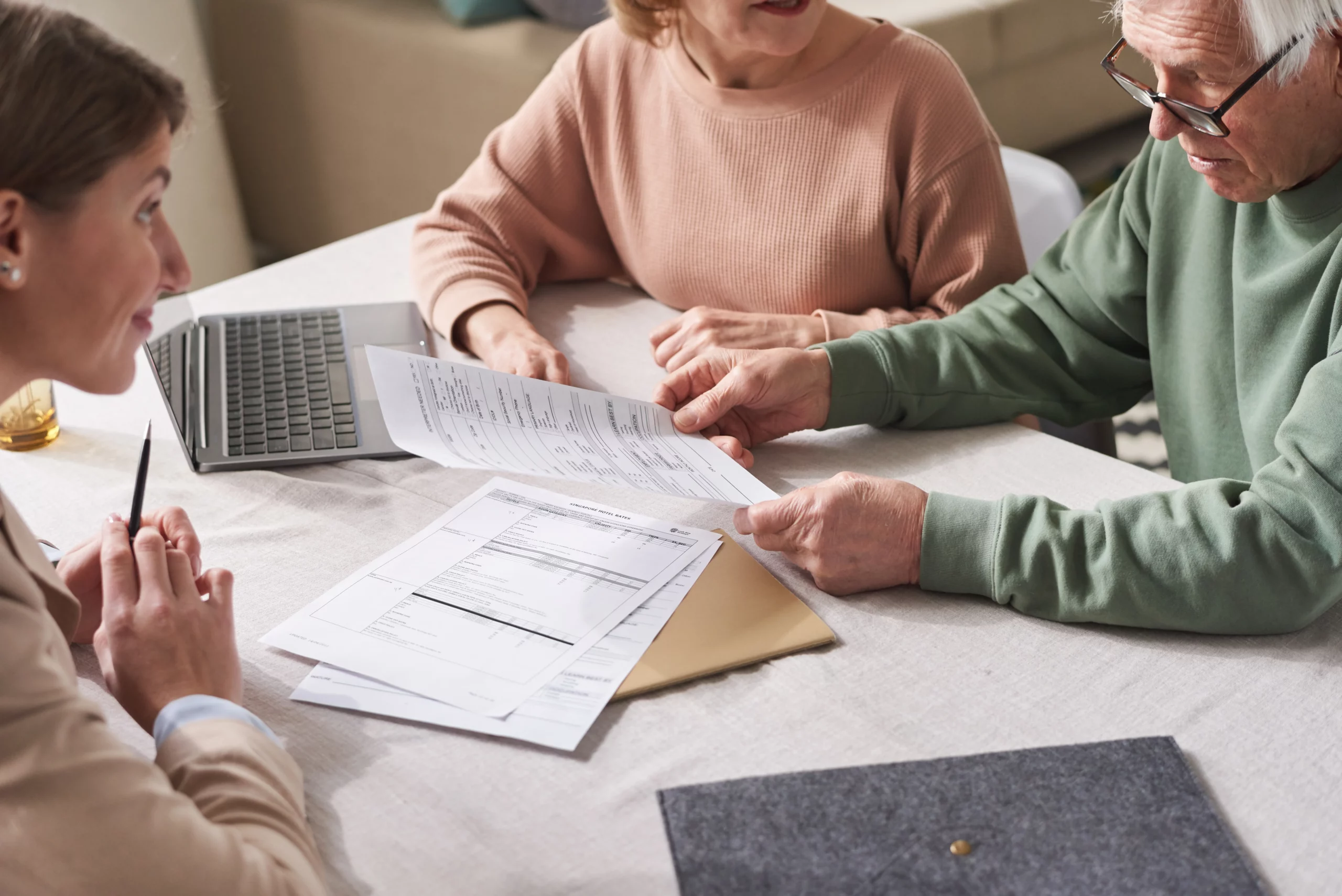 Older couple reviewing estate planning documents with financial advisor, symbolizing Florida estate planning decisions such as choosing between a will and a trust to control asset distribution, avoid probate, and protect family inheritance.