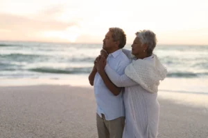 Elderly couple embracing on beach, Florida trust and will estate planning