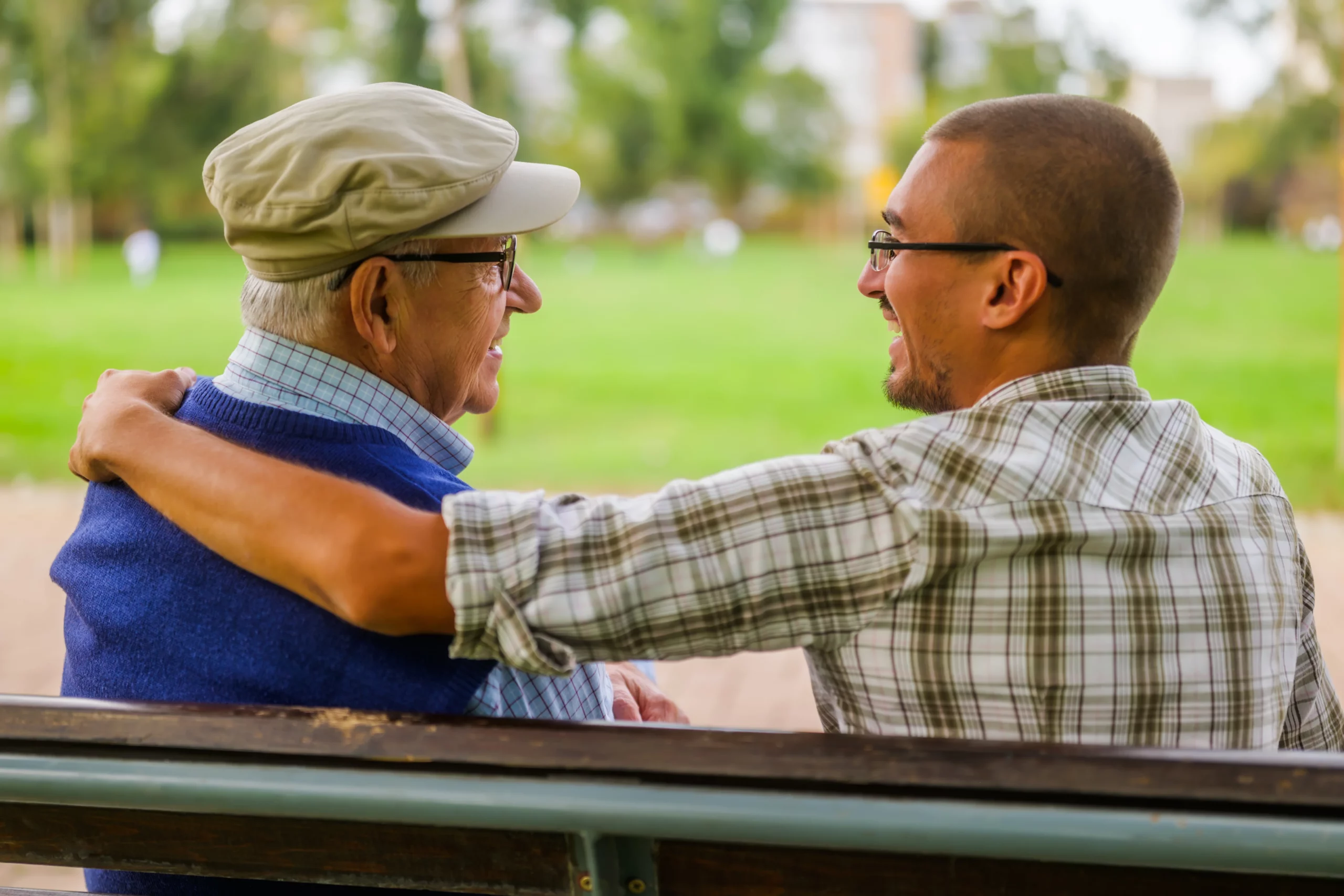 Man and older guardian sharing supportive conversation on park bench, symbolizing situations where guardianship may be necessary when an adult or minor cannot fully manage personal care or decision-making without assistance.