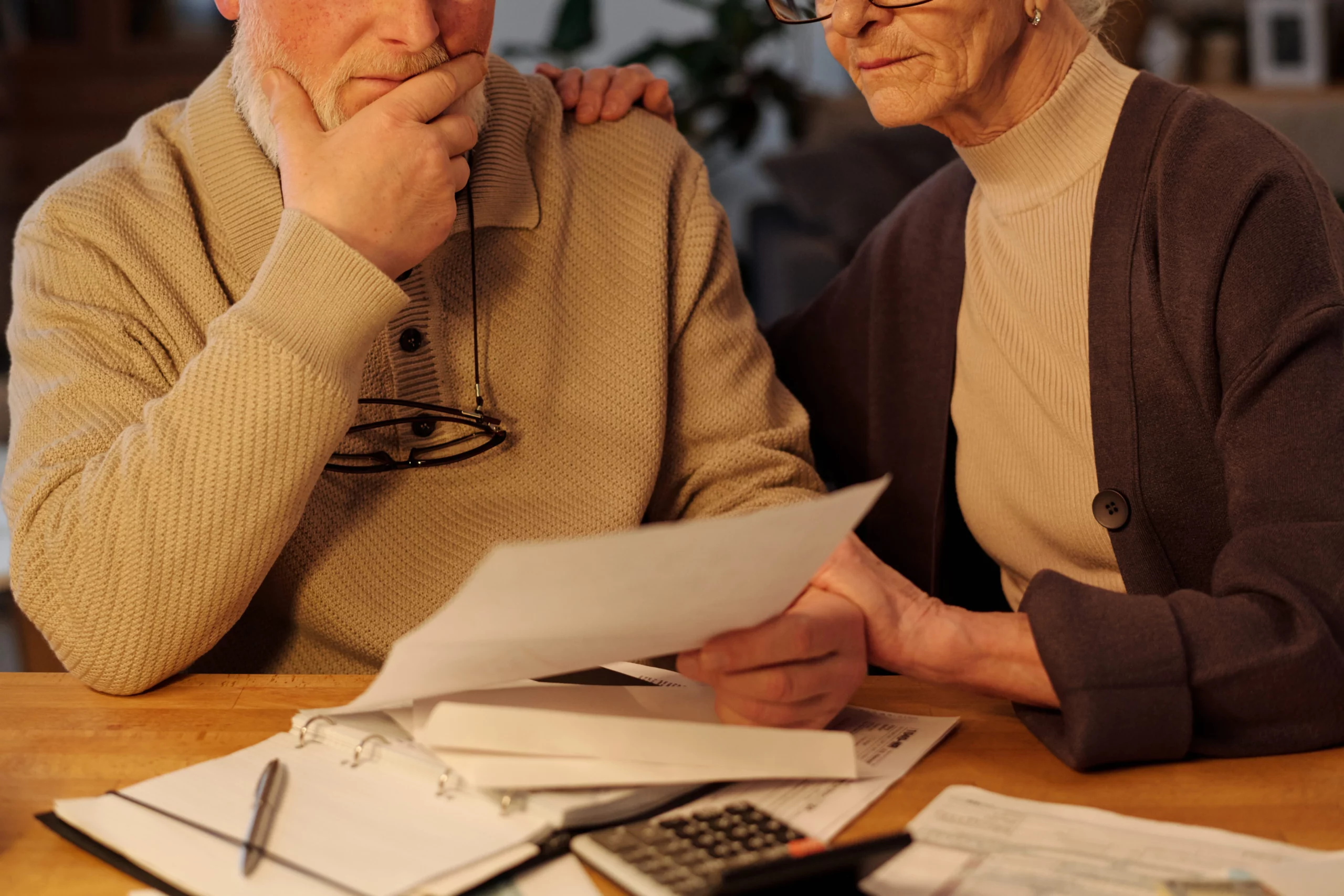 Older couple reviewing estate planning documents and bills at home in Melbourne, Florida